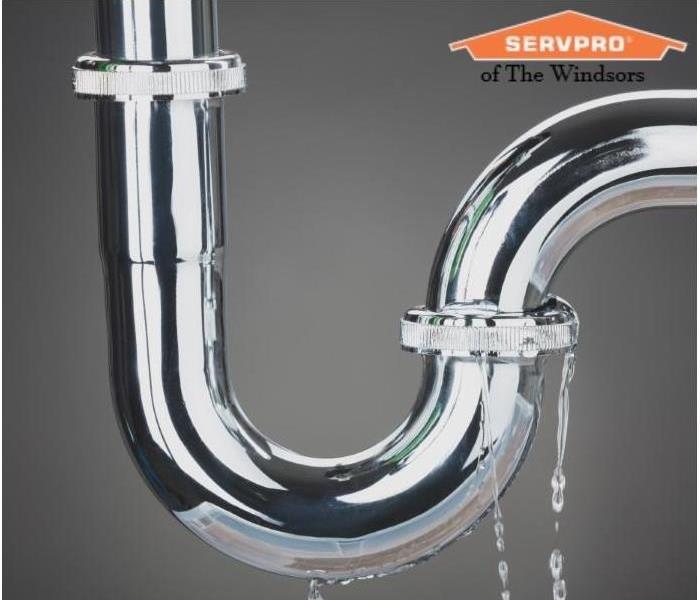 Silver sink plumbing leaking water on grey background with SERVPRO of The Windsors Photo
