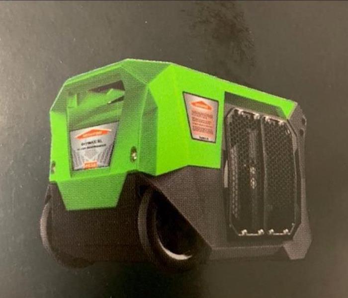Small green and black dehu with servpro logo against black backdrop